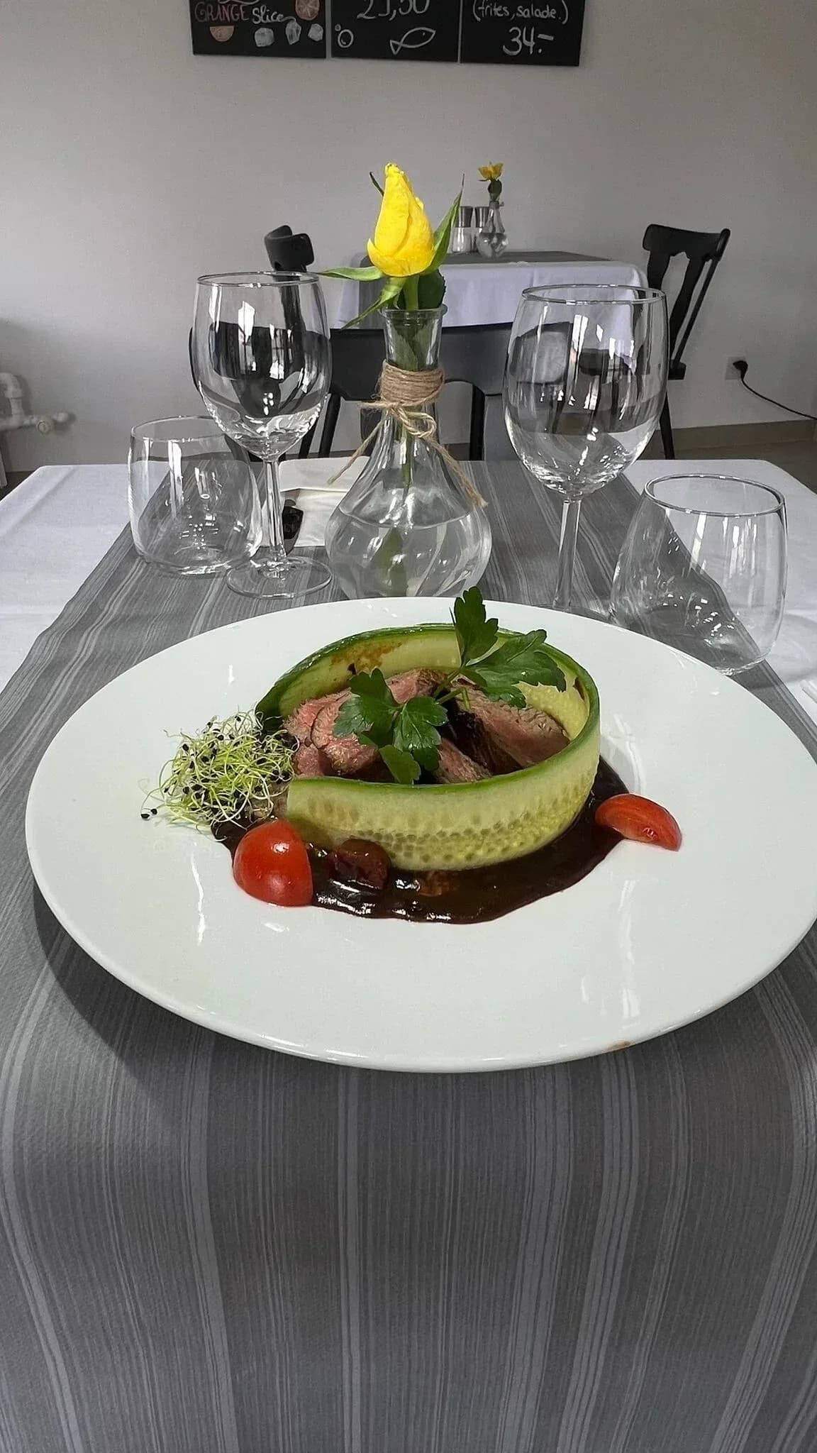 Aufgeschnittenes Rindfleisch in einem Gurkenband, braune Sauce und Sprossen