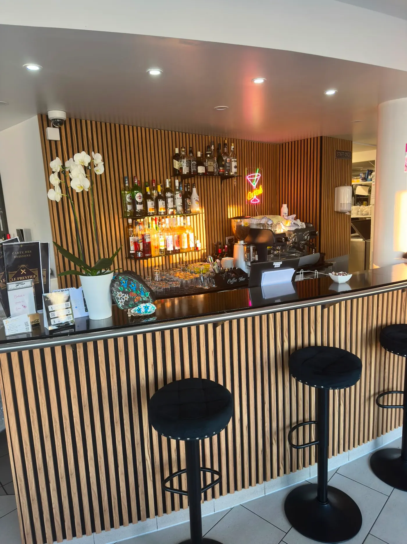 Die Bar von vorn, die aufgereihten Flaschen und die schwarzen Hocker