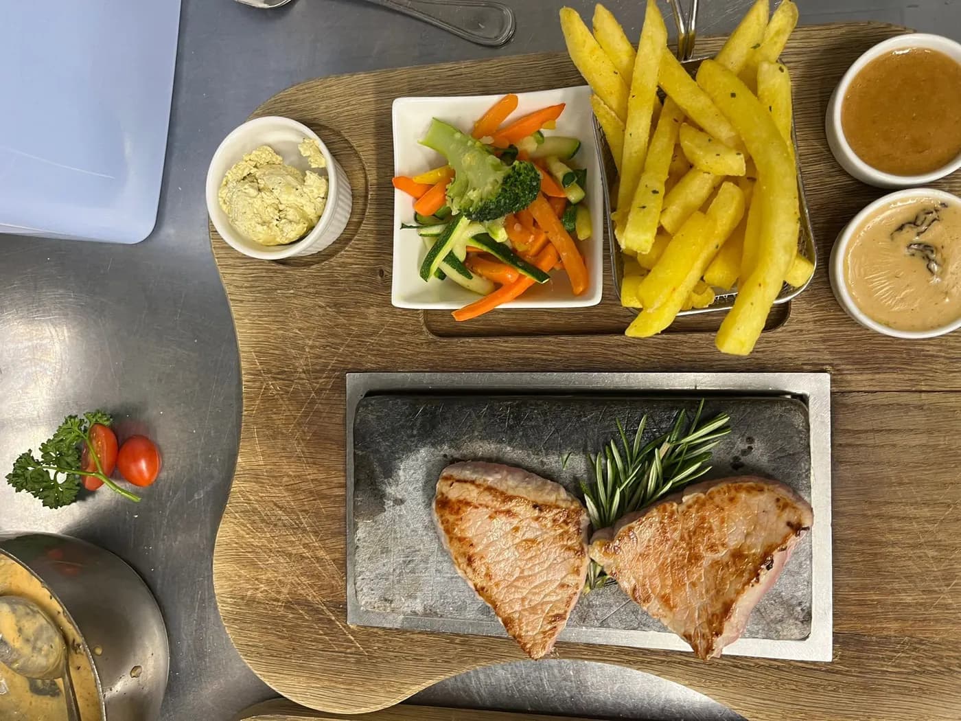Meat served on a hot stone, turned vegetables and sauce on the side